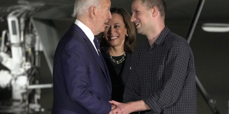 FILE - President Joe Biden, from left, and Vice President Kamala Harris greet reporter Evan Gershkovich at Andrews Air Force Base, Md., following his release as part of a 24-person prisoner swap between Russia and the United States, Aug. 1, 2024. Bloomberg News is apologizing for a premature story written about the prisoner exchange and says it has disciplined the journalists involved. The story was put out by Bloomberg hours before an embargo was lifted by the White House. (AP Photo/Manuel Balce Ceneta, File)