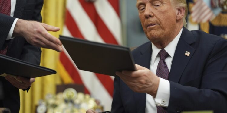 President Donald Trump signs executive orders in the Oval Office of the White House, Monday, Jan. 20, 2025, in Washington. (AP Photo/Evan Vucci)